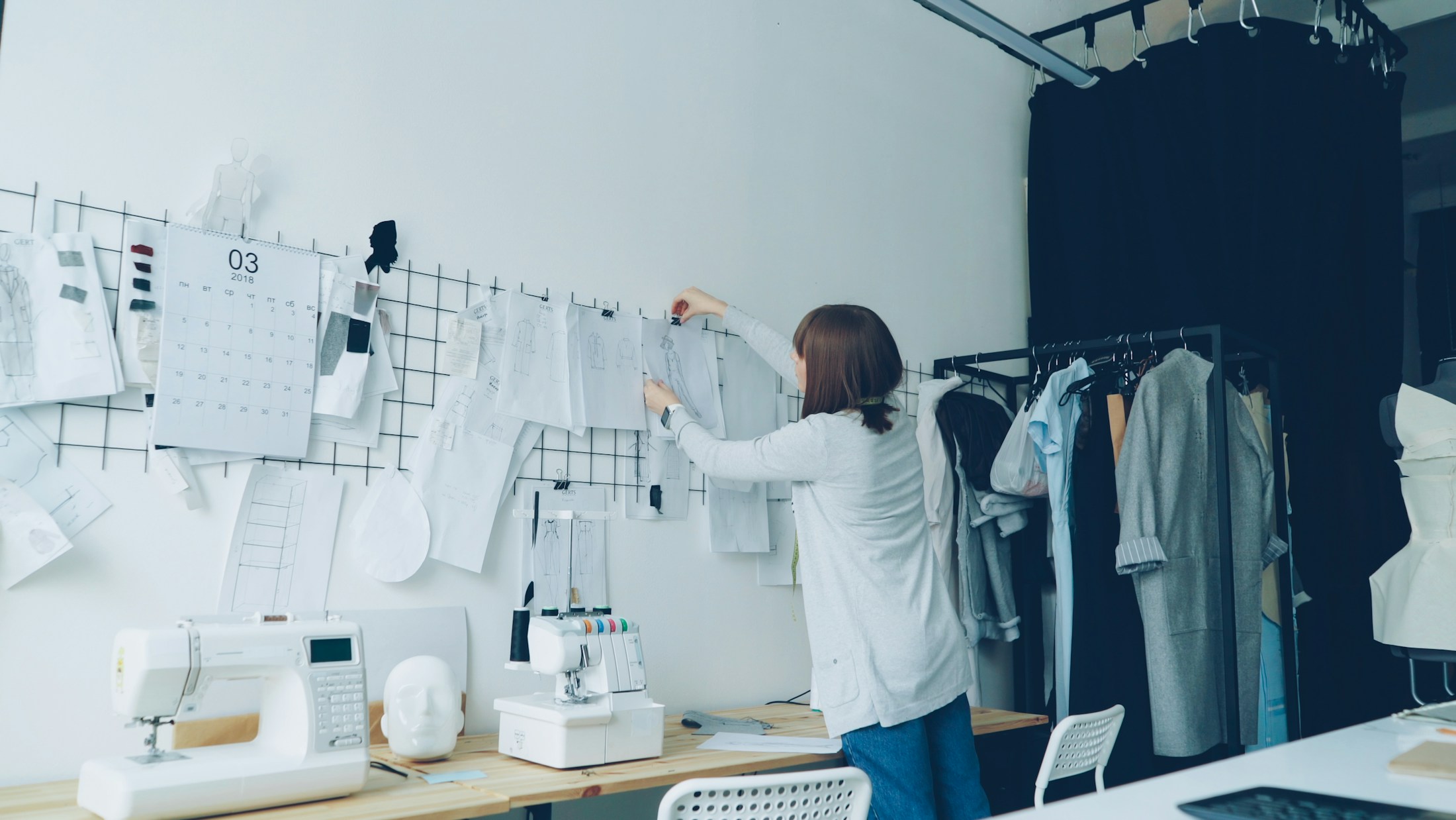 Designer arranging technical drawings in a fashion studio